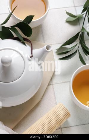 Composition with teapot and cups of tea on white tile background, closeup Stock Photo
