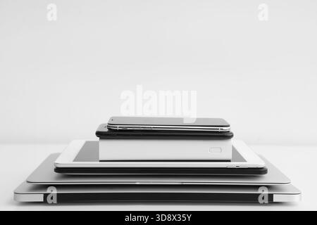Stack of different modern gadgets on light background Stock Photo
