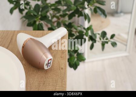 Modern photoepilator on table in bathroom, closeup Stock Photo