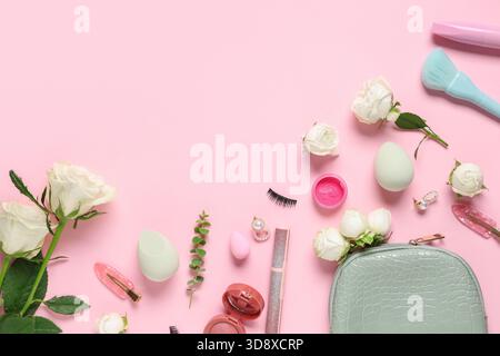 Frame made of white rose flowers and makeup products on pink background Stock Photo