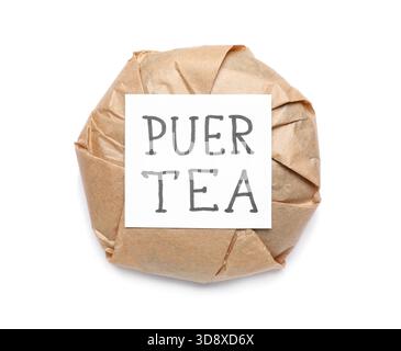 Dry pressed puer tea wrapped in paper and sticky note on white background Stock Photo