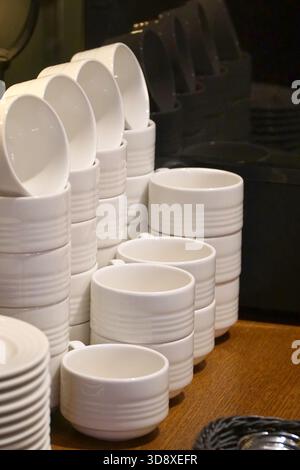 The stack of white coffe cups, tea cups on wooden table. Concept of catering, buffet, coffee break, party. Stock Photo
