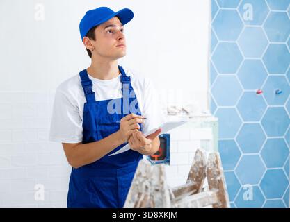 Focused contractor taking notes while planning renovation works in building Stock Photo
