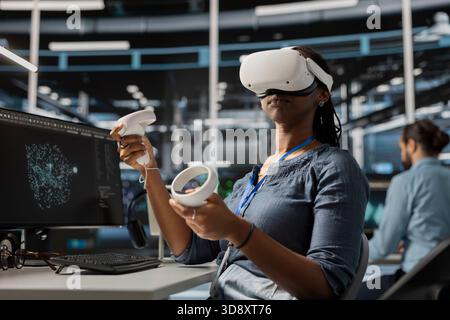 Data center engineer running diagnostic scripts using VR headset, examining equipment. Server room worker using virtual reality to evaluate rackmounts performance metrics, maintaining system stability Stock Photo