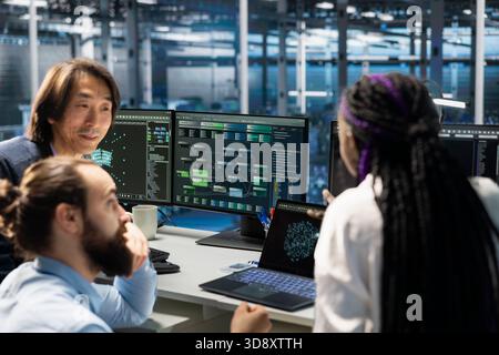 Team of engineers working in server farm with hardware supporting advanced analytics tasks and data mining. Data center teamworking colleagues doing maintenance on racks storing blockchain records Stock Photo