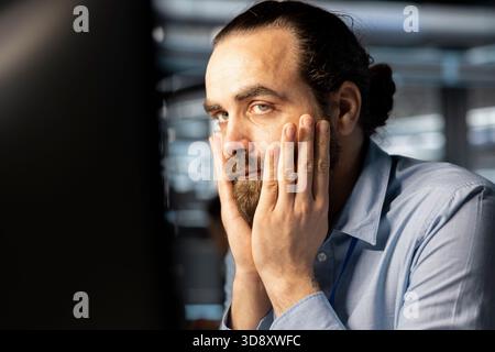 Data center cybersecurity worker scared by security breach. Worried IT staff member in data center panicking, trying to protect servers from hacker attack stealing sensitive information Stock Photo