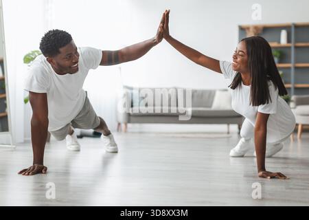 Young black couple planking and giving high five Stock Photo