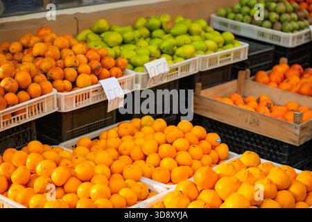Yerevan Armenia 11.25.2025. A fruit stand with a variety of oranges and apples. The oranges are in a white container and the apples are in a black con Stock Photo