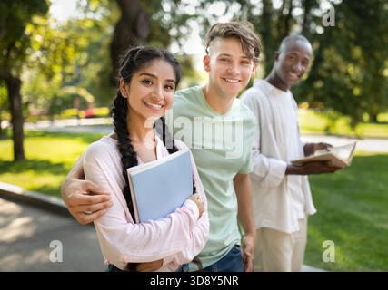 Students Enjoy a Sunny Afternoon in the Park While Studying Together and Sharing Smiles With Friends Stock Photo