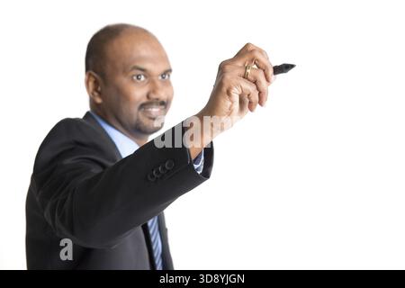Mature Indian business male in formalwear writing something on glass board with marker, focus on hand Stock Photo