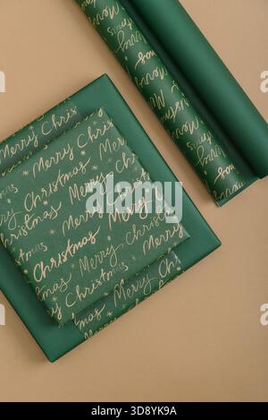Stack of green gift boxes with wrapping paper on golden background, top view Stock Photo