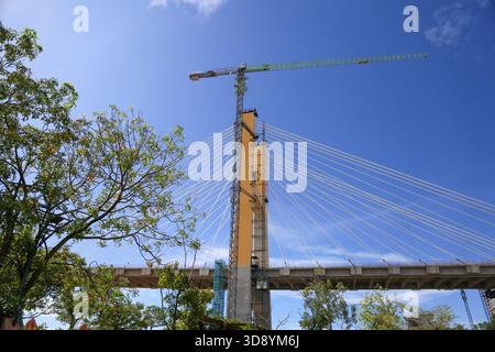 Cable-Stayed Bridge Construction with Tower Crane Under Blue Sky Stock Photo