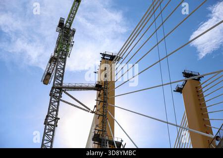 Cable-Stayed Bridge Construction with Tower Crane Under Blue Sky Stock Photo