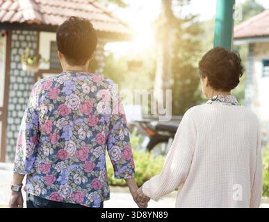Rear view Asian elderly women walking in garden park Stock Photo - Alamy