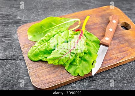 Swiss chard with red, yellow and white veins on wooden board background Stock Photo