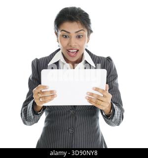 Black business woman using tablet pc and getting shocked, isolated on white background Stock Photo