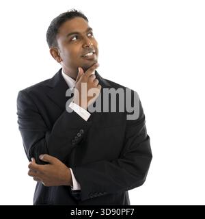 Indian man thinking. Confident young Indian businessman thinking, looking up and standing isolated on white background Stock Photo
