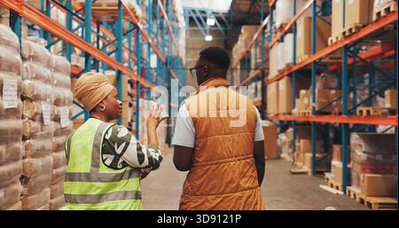 Shipping, talking and back of people in warehouse for inspection, supply chain and planning. Factory, distribution and workers in meeting for Stock Photo