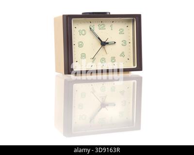 Vintage-style alarm clock with reflection on glossy surface Stock Photo