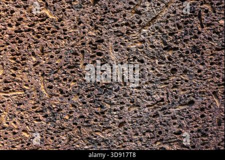 Texture Abstract background of brown pitted rock surface showing natural geological pattern and weathered details of old volcanic material and soil Stock Photo
