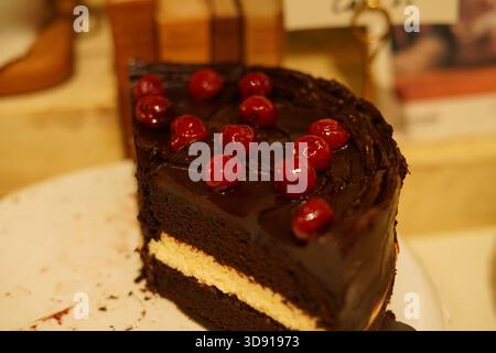 Decadent Slice of Chocolate Layer Cake with Cherries on Top Stock Photo