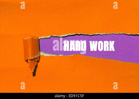 Hard Work message written on ripped torn paper background. Conceptual Hard Work symbol. Copy space. Stock Photo