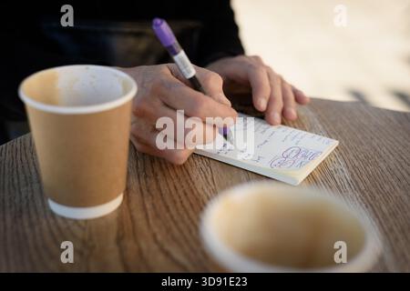 A notepad for to-do-notes to help navigate and organise modern life's many commitments and obligations at a local coffee shop Stock Photo