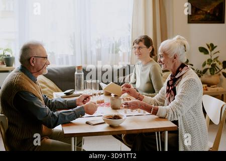 Senior Couple Playing Board Game with Middle Aged Woman Stock Photo