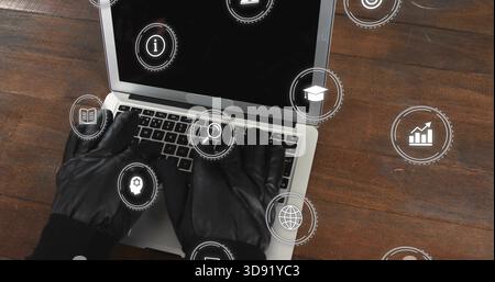 Typing black-gloved hands in dark sleeves, operating silver laptop on dark table with HUD icons Stock Photo