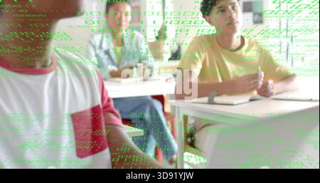 Writing student in yellow tee taking notes with pen in classroom, green code overlay, copy space Stock Photo