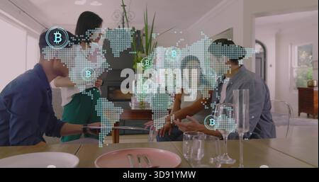 Meeting team in casual attire around wooden dining table at home, viewing tablet with Bitcoin map Stock Photo