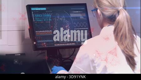 Viewing woman wearing labcoat gloves and goggles analyzing data onscreen at lab desk, copy space Stock Photo
