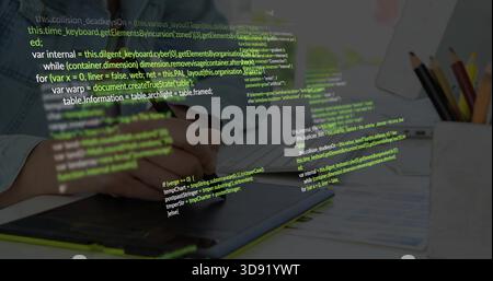 Working hands in denim shirt, using stylus editing on graphics tablet at desk, code overlay Stock Photo