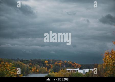 Very gloomy sky over the river, distant houses Stock Photo