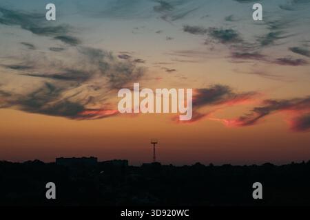 Peach gradient sunset, soft clouds, large metal structure Stock Photo