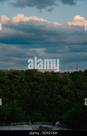 Cloudy summer evening sky over the forest near the river Stock Photo
