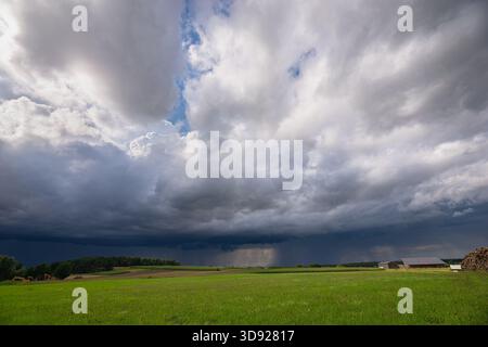 Dramatic thundery sky over open Bavarian countryside with fields and distant farms Stock Photo