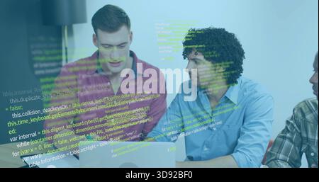 Discussing three men leaning over laptop at office table, pink and light blue shirts, code overlay Stock Photo