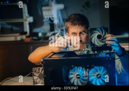 Man assembles a computer system unit at home Stock Photo
