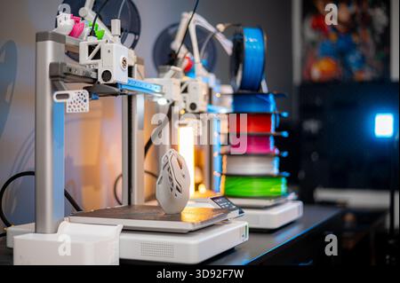 row of colorful 3d printing filament PLA material on environmentally friendly and recyclable paper cardboard spools on black carbon fiber background Stock Photo