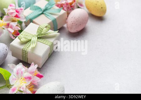 Pastel eggs and gift boxes with flowers on a light background Stock Photo
