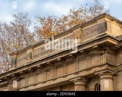 Angled view of the 1839 inscription on the stone cornice of the North Lodge entrance of Brompton Cemetery, seen from Old Brompton Road. London. UK Stock Photo