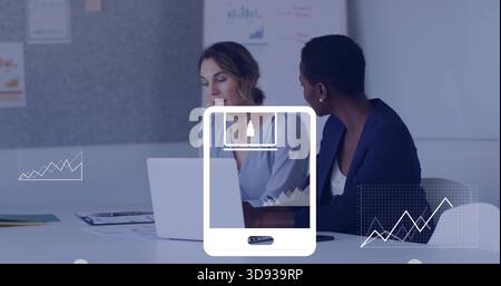 Discussing women in blazer and blouse using laptop at meeting room, with charts and phone overlay Stock Photo