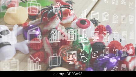 Showing Halloween candy on wood table, with plastic eyes, skull, spider, gummies, analytics overlay Stock Photo