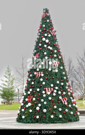 Decorated Christmas tree with red and white ribbons in the city Stock Photo