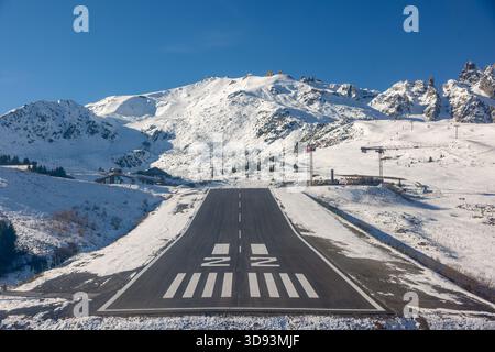Short-final view of runway 22 at Courchevel Altiport (LFLJ) on a clear late-autumn day, photographed on 5 November 2025. Snow-covered slopes and the c Stock Photo