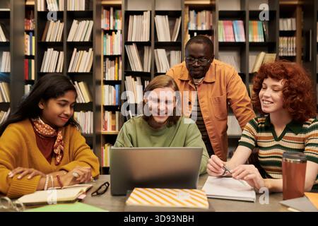Multiethnic Young People Collaborating on Project in Library Setting Stock Photo