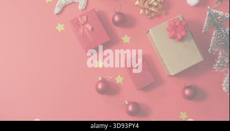 Displaying medium kraft cardboard gift box with red bow on red tabletop, plus baubles, copy space Stock Photo