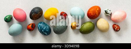 Various Easter eggs in vibrant colors and patterns are neatly arranged, showcasing the joy and creativity associated with spring celebrations and fami Stock Photo