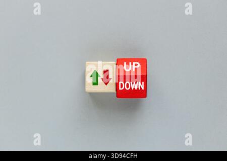 Up and down, Arrow Symbol, up and down. Increases and decreases. Business concept. A red cube with the words "Up" and "Down" spinning. Gray background Stock Photo